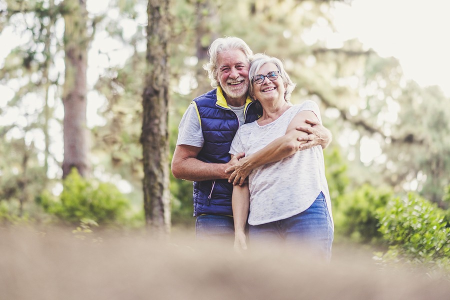 Couple of ol caucasan people mature man and woman hug together in. relationship - outdoor leisure activity for active senior - happiness and joy for retired lifestyle