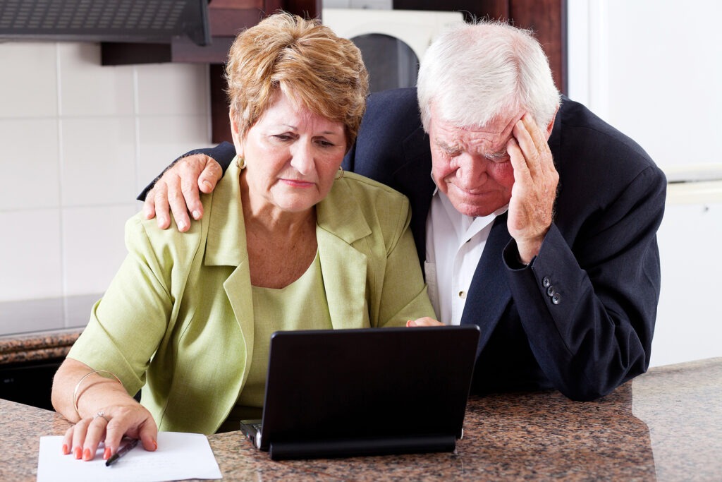 unhappy senior couple worrying about expenses at home